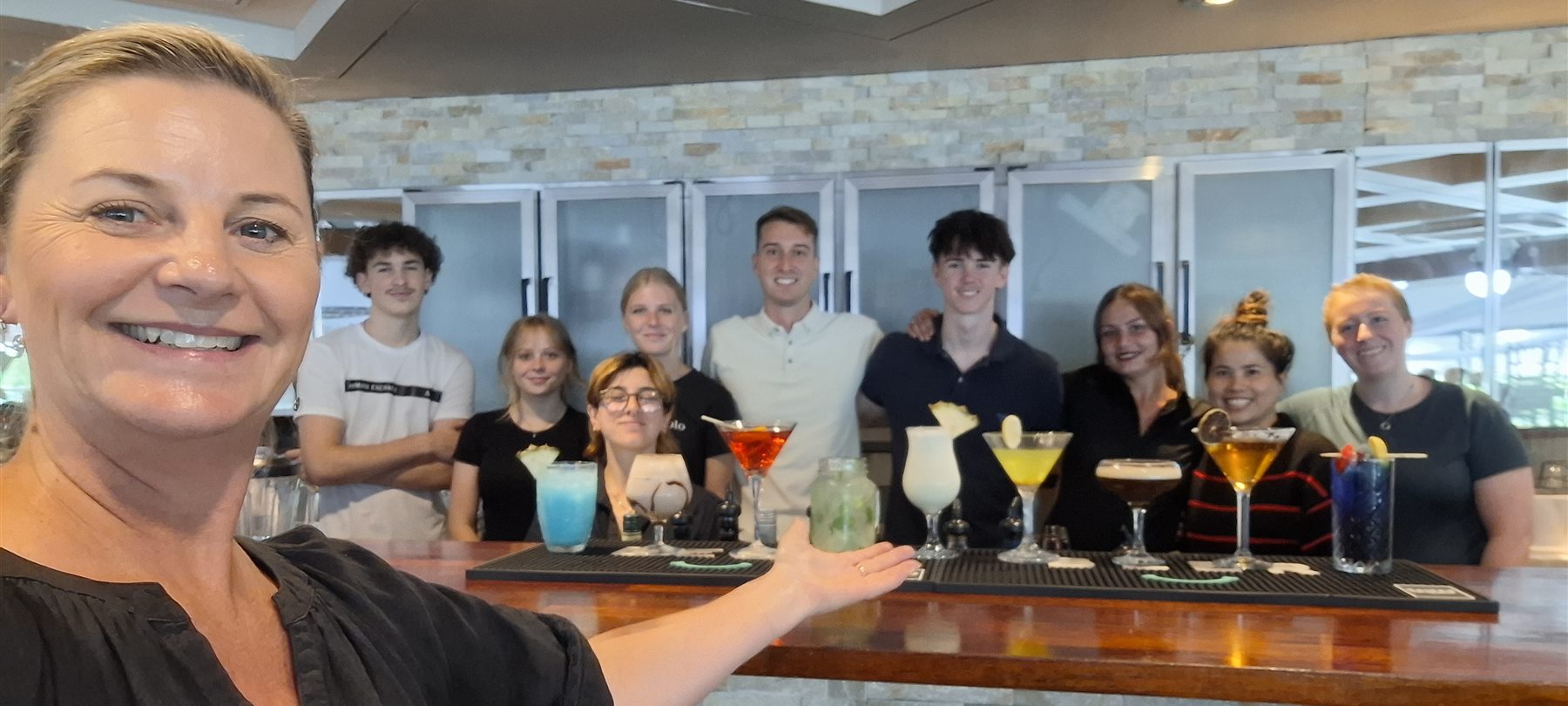 Jacqui Dean with a hospitality team and the cocktails they made during bar and guest service training